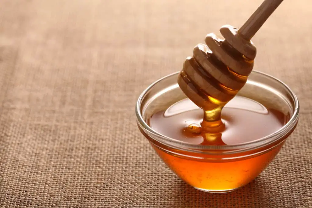 honey dripping into a jar