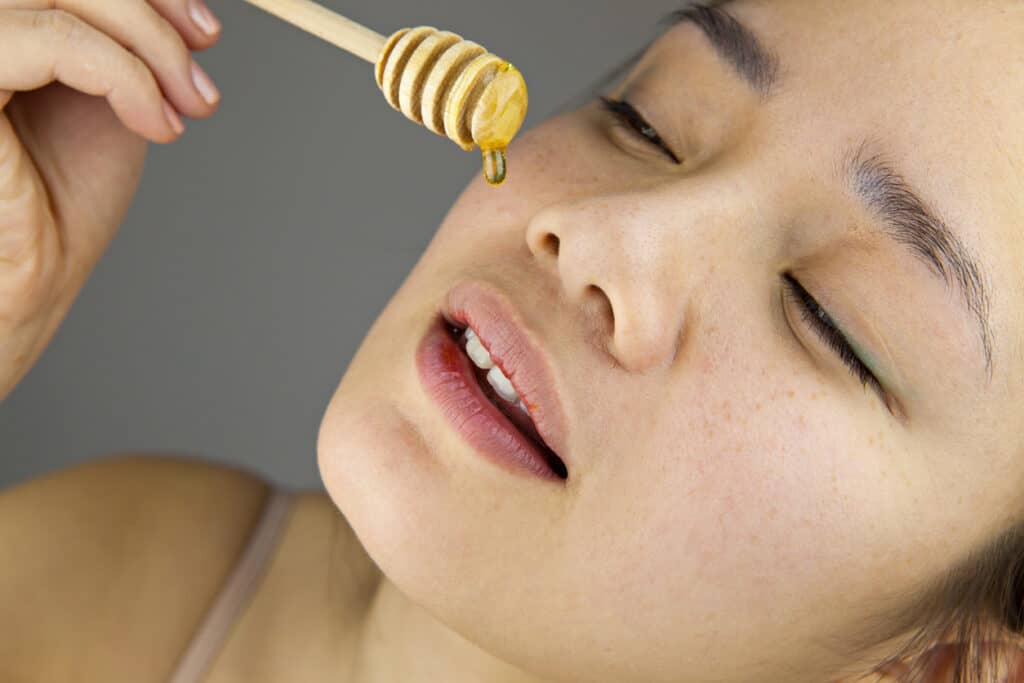 honey dripping onto face