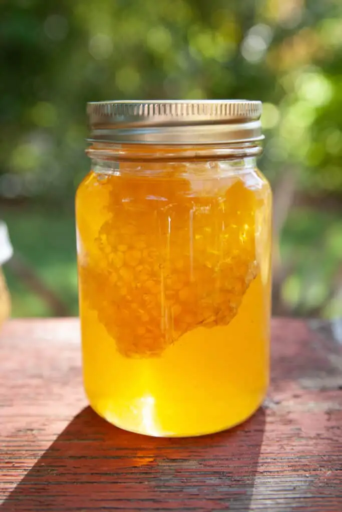 honey with comb inside of jar