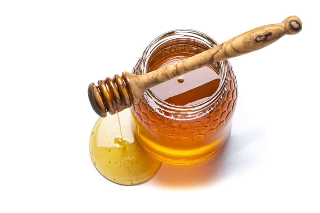 honey in a jar with a wand